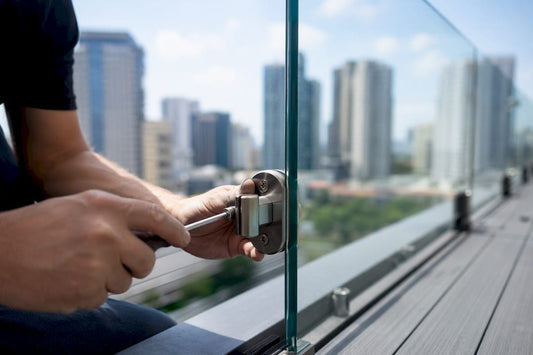 Hands installing glass handrail bracket on deck