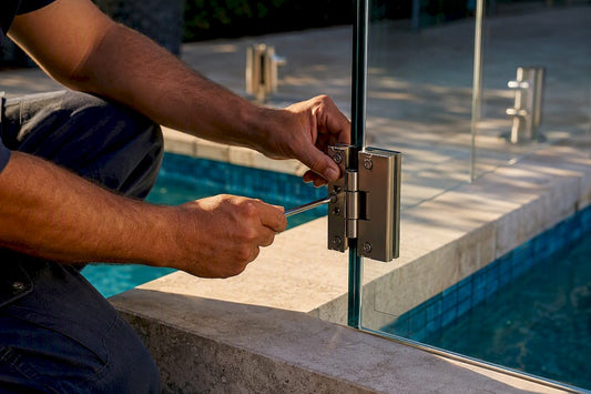 Hands installing glass pool gate hinges