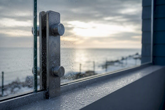 Glass railing post with salt residue on coastal home