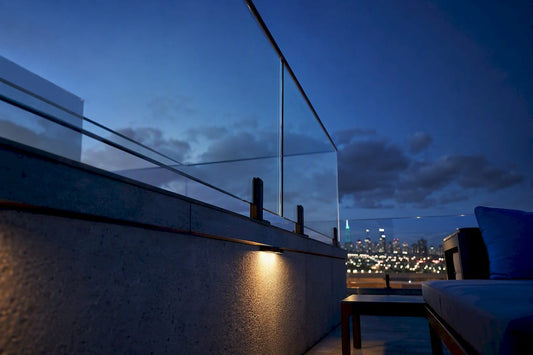 Rooftop glass railing against evening skyline