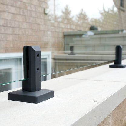 Six inch engineered spigot anchored to a concrete deck, holding a frameless glass panel