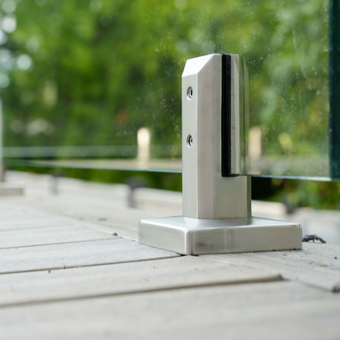 Brushed stainless 6 inch glass railing spigot mounted on a wood deck surface