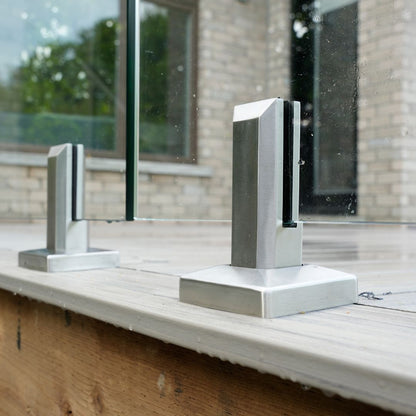 Brushed stainless spigot gripping a 12mm tempered glass railing panel