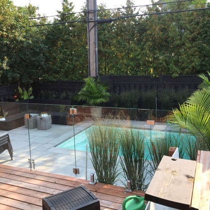 Spigot-mounted glass pool fence beside a swimming pool