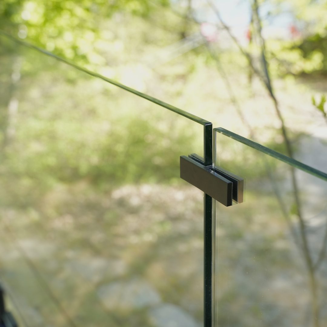 Glass-to-glass connector securing tempered panels