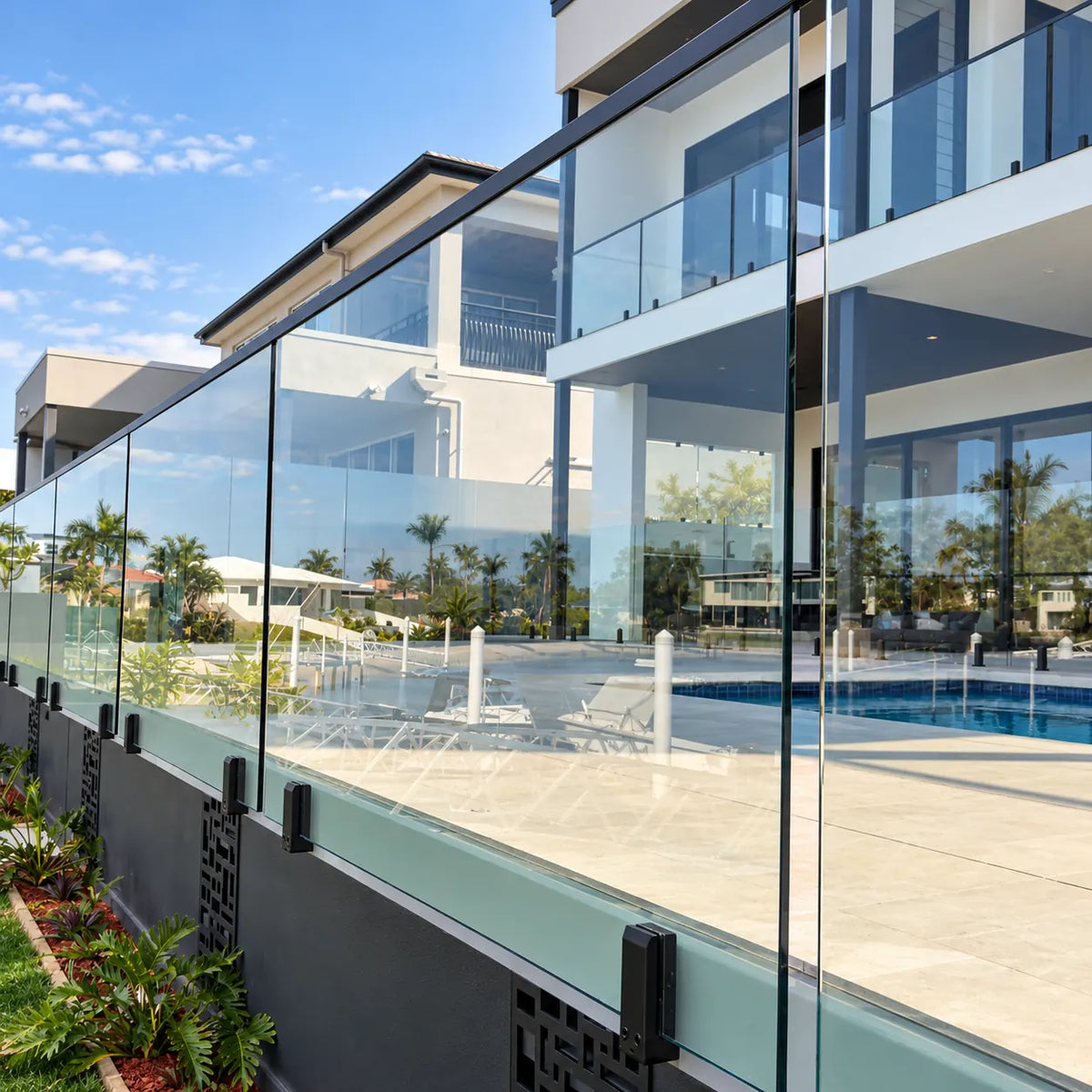 Modern outdoor glass railing installed with matte black side-mount fascia spigots along a contemporary residential balcony.